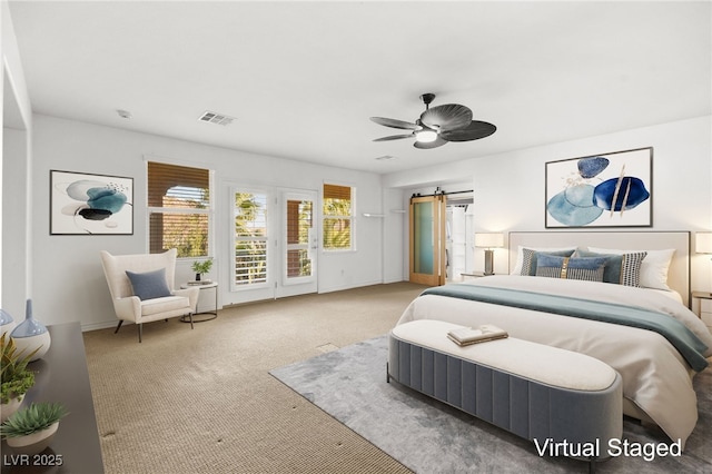 carpeted bedroom with ceiling fan, access to exterior, and a barn door