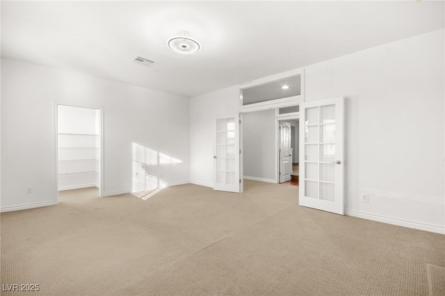 carpeted spare room with french doors