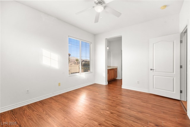 unfurnished bedroom featuring ceiling fan, ensuite bath, and light hardwood / wood-style flooring