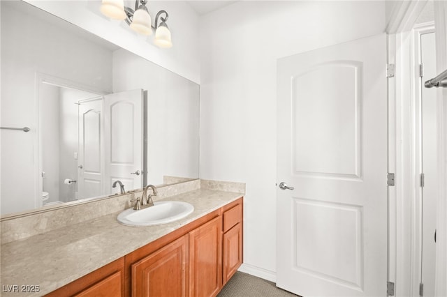 bathroom with toilet, vanity, and tile patterned floors