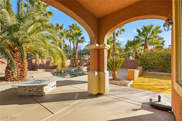 view of patio featuring a fenced in pool and a fire pit