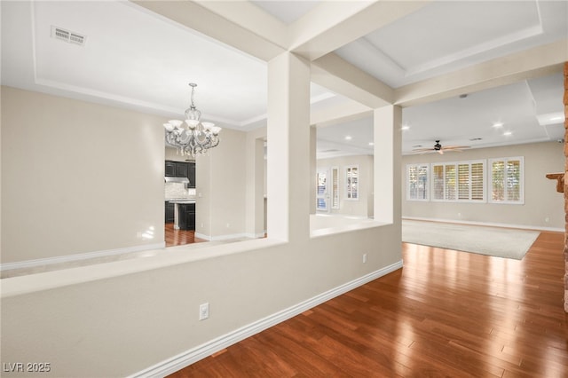 spare room featuring ceiling fan with notable chandelier and hardwood / wood-style floors