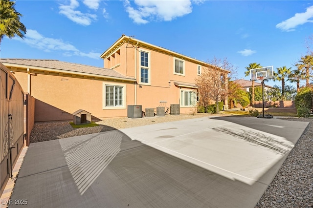 back of property with central AC unit and basketball court