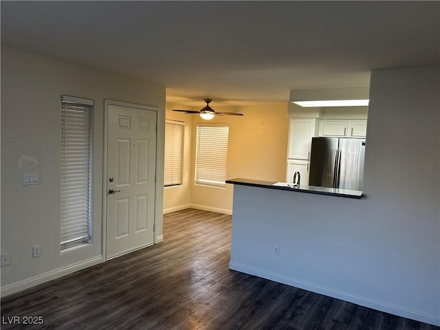 kitchen featuring ceiling fan, sink, stainless steel refrigerator, white cabinets, and dark hardwood / wood-style flooring