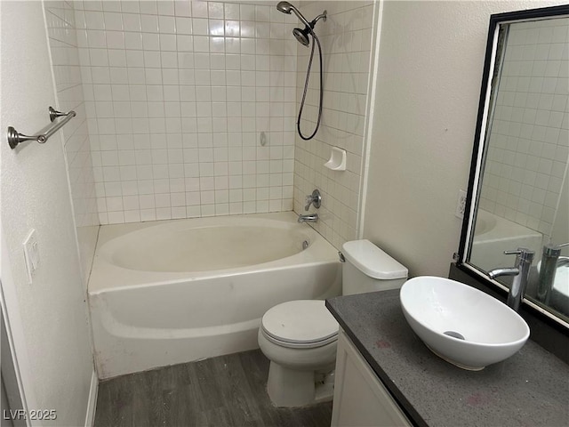 full bathroom with toilet, vanity, tiled shower / bath combo, and hardwood / wood-style floors