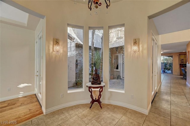 hallway featuring light tile patterned floors and a chandelier