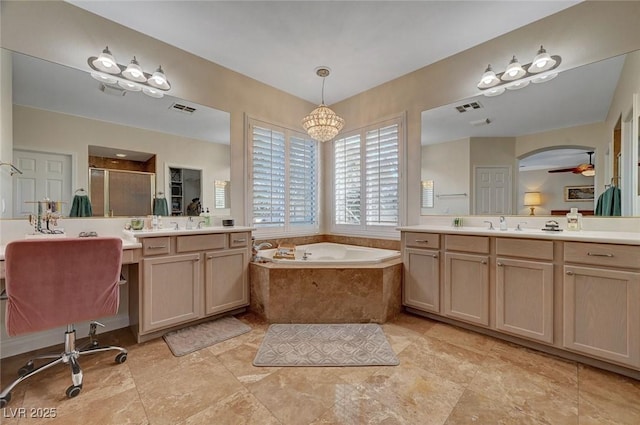 bathroom with vanity, ceiling fan with notable chandelier, and plus walk in shower