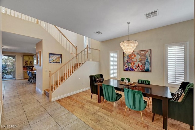 tiled dining area with plenty of natural light and an inviting chandelier