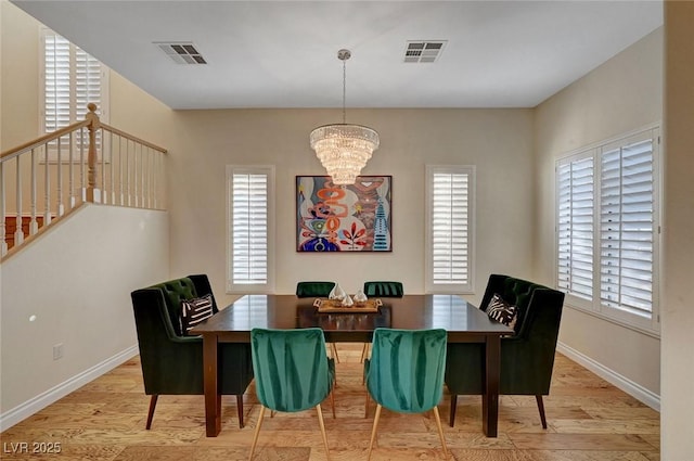 dining space featuring light wood-type flooring and a chandelier