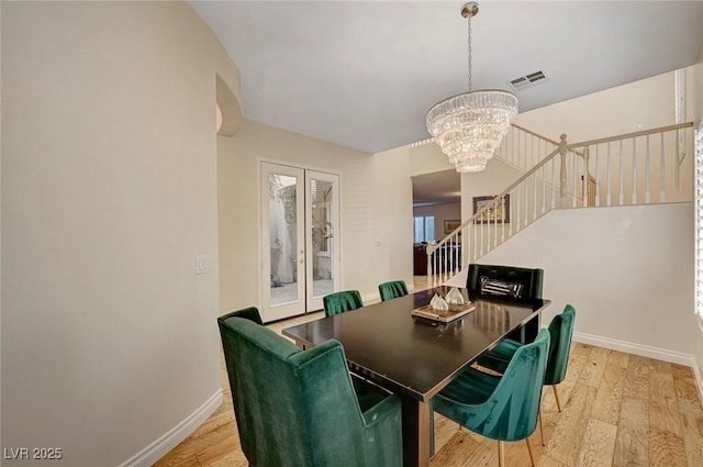 dining area featuring light wood-type flooring and a chandelier