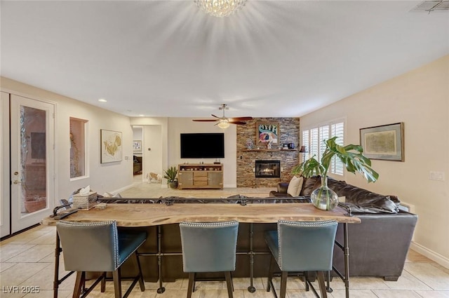 kitchen featuring ceiling fan, light tile patterned floors, and a kitchen bar