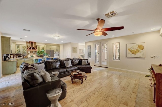 living room with ceiling fan, french doors, and light hardwood / wood-style flooring