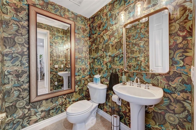 bathroom featuring toilet, sink, and tile patterned floors