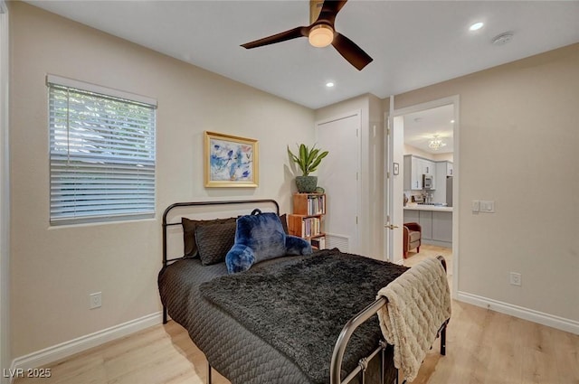 bedroom with ceiling fan, light hardwood / wood-style floors, and connected bathroom