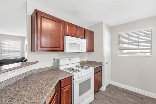 kitchen featuring dark wood-type flooring, plenty of natural light, and white appliances