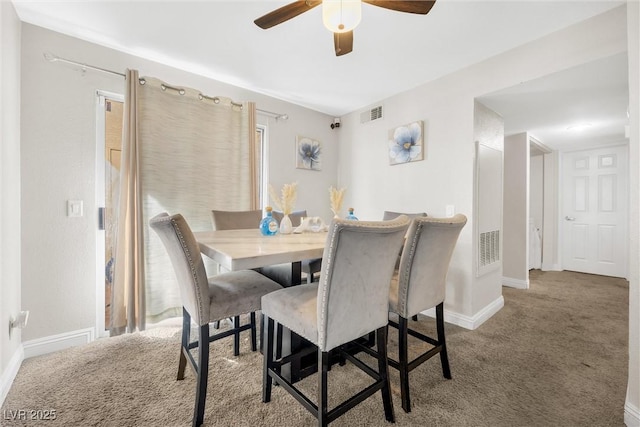 carpeted dining area with ceiling fan