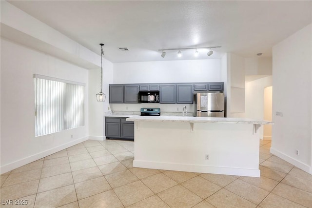 kitchen featuring a kitchen bar, stainless steel refrigerator, hanging light fixtures, range with electric stovetop, and gray cabinetry