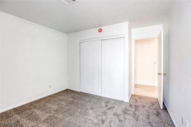 unfurnished bedroom featuring carpet floors and a closet