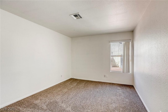 carpeted empty room with a textured ceiling