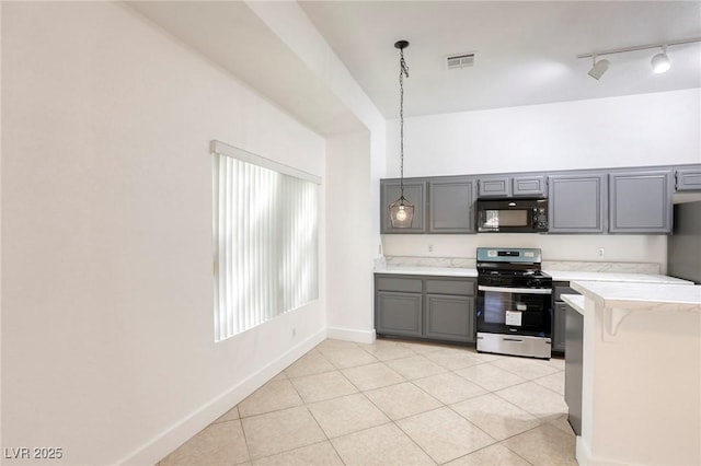 kitchen with hanging light fixtures, stainless steel range with gas cooktop, gray cabinetry, and light tile patterned flooring