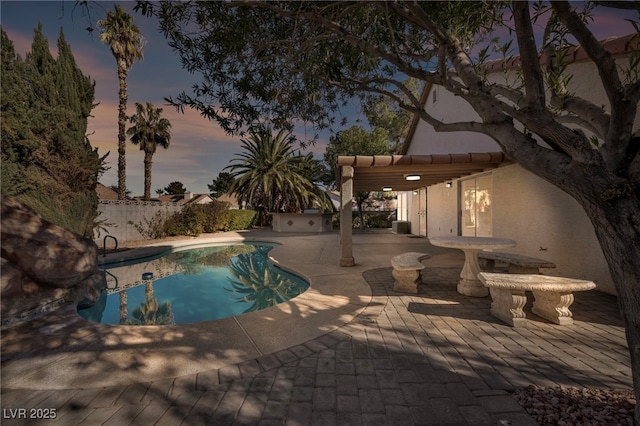 pool at dusk with a patio