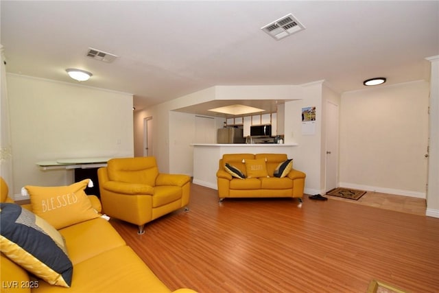 living room featuring crown molding and hardwood / wood-style flooring