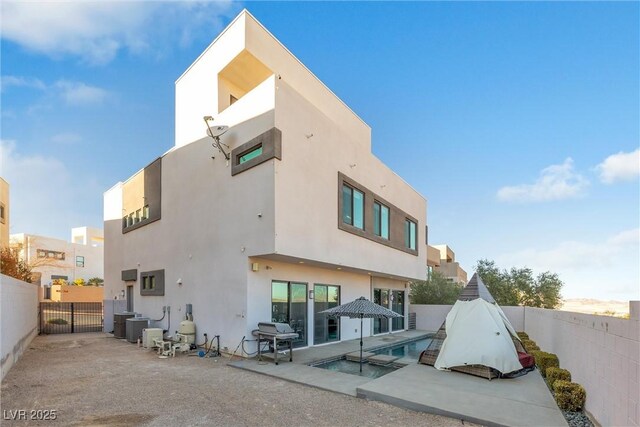 rear view of house featuring a patio area and a fenced in pool