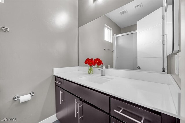 bathroom with a shower with shower door and vanity