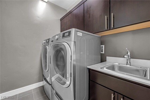 laundry room featuring cabinets, light tile patterned floors, separate washer and dryer, and sink