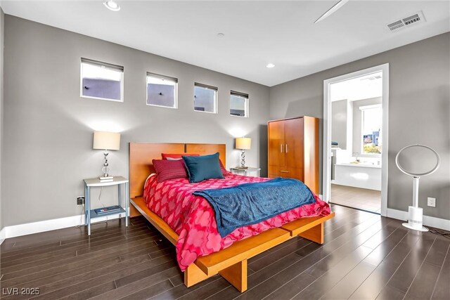 bedroom featuring ensuite bathroom and dark hardwood / wood-style flooring