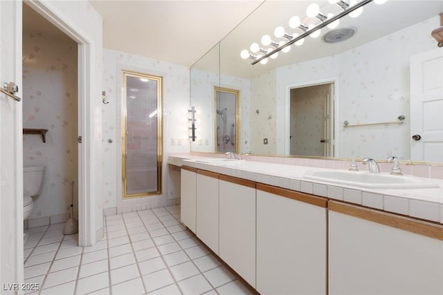 bathroom with toilet, vanity, an enclosed shower, and tile patterned flooring