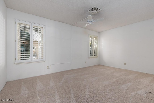 spare room featuring ceiling fan, a textured ceiling, and carpet flooring