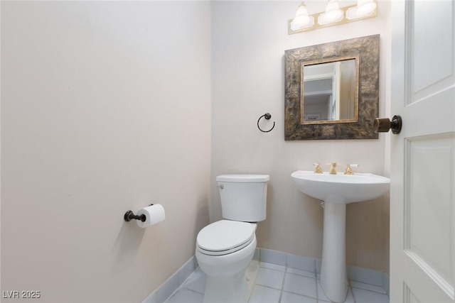 bathroom featuring toilet, tile patterned flooring, and sink