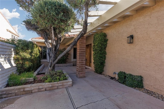 view of exterior entry featuring a patio area