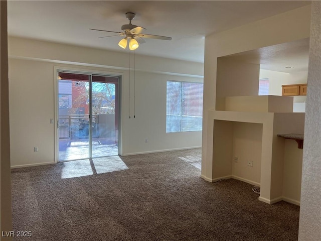 spare room featuring ceiling fan and dark carpet