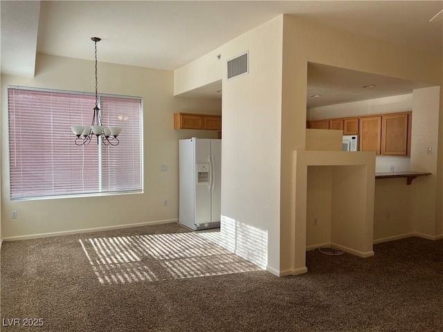 kitchen with carpet, a notable chandelier, pendant lighting, kitchen peninsula, and white fridge with ice dispenser