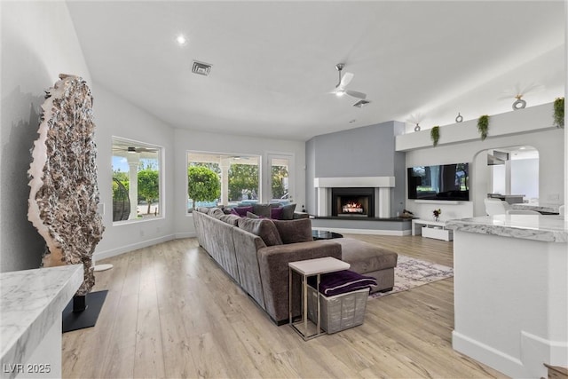 living room with ceiling fan, lofted ceiling, and light hardwood / wood-style flooring