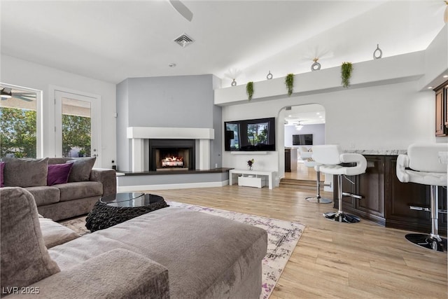 living room featuring light wood-type flooring, ceiling fan, and lofted ceiling