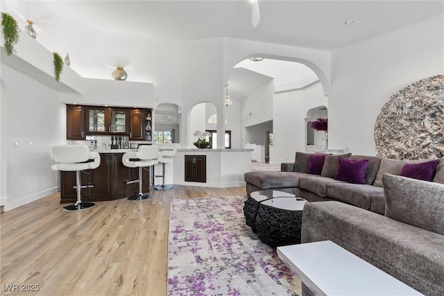 living room featuring a high ceiling and light hardwood / wood-style flooring