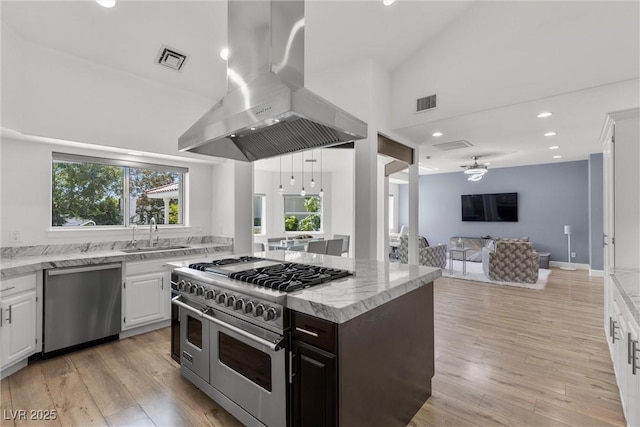 kitchen with sink, island exhaust hood, stainless steel appliances, and white cabinetry