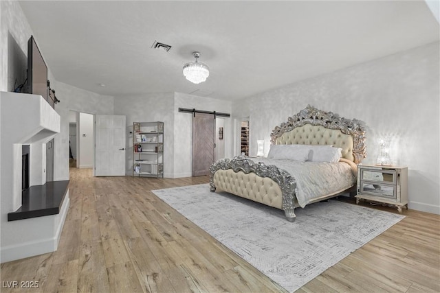 bedroom featuring light hardwood / wood-style floors and a barn door