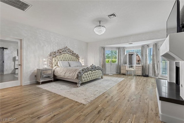 bedroom with a chandelier and light hardwood / wood-style flooring