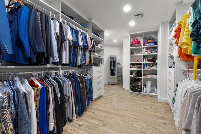 walk in closet with light hardwood / wood-style floors