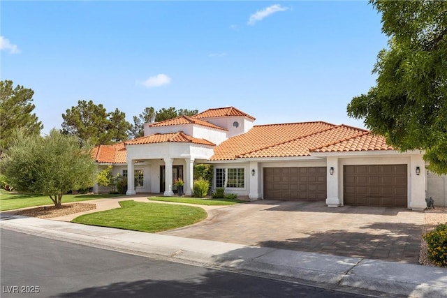 mediterranean / spanish-style home with a front lawn and a garage