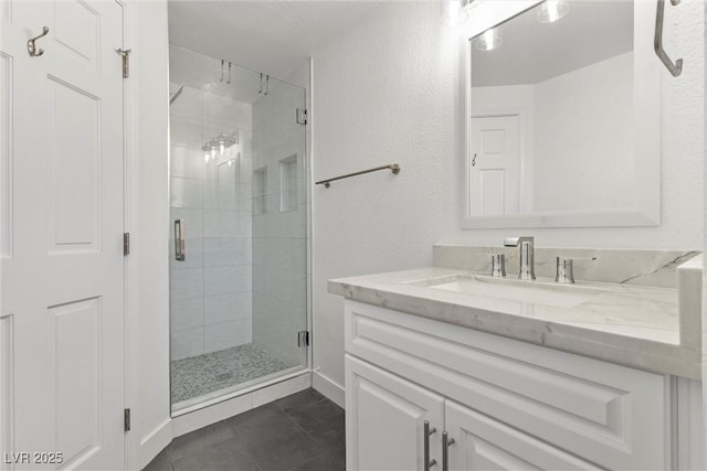 bathroom featuring a shower with shower door, vanity, and tile patterned flooring