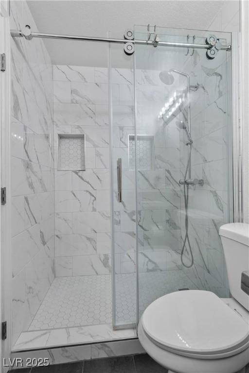 bathroom featuring walk in shower and toilet