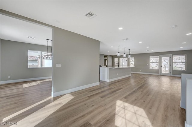 unfurnished living room featuring light hardwood / wood-style floors and sink