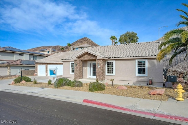 view of front of house with a garage and central air condition unit