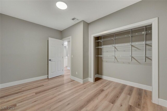 unfurnished bedroom featuring a closet and light hardwood / wood-style flooring