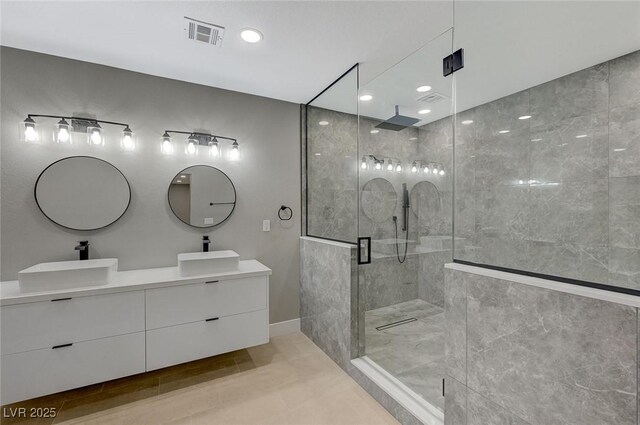 bathroom featuring tile patterned flooring, a shower with door, and vanity